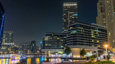 Dubai Marina, yatları ve briç gecesi hiperhızlandırılmış restoranları olan modern kuleleri olan, Birleşik Arap Emirlikleri ile dolanıyor. Gökdelenlerde parlayan pencereler