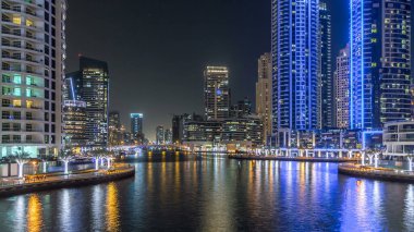 Dubai Marina 'da yatları ve Dubai' deki köprüden restoranları olan modern kuleleri olan bir gezinti alanı, Birleşik Arap Emirlikleri. Yapay kanalla aydınlatılmış bölge