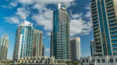 Dubai Marina Kanal Panorama 'sı yatları ve modern kuleleri ile Dubai' deki deniz kıyısından yansıtılan yeşil su, Birleşik Arap Emirlikleri. Yapay kanal ve gökdelenler