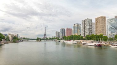 Eyfel Kulesi ve Özgürlük Anıtı modern binalar ve yol trafiği yüksek hızda giderken suya yansıdı. Gün batımından önce Mirabeau Köprüsü 'nden görüntü. Paris, Fransa