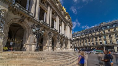 Palais veya Opera Garnier Ulusal Müzik Akademisi Paris, Fransa 'da zaman aşımına uğradı. Girişe giden merdivenler. İnsanlar sokakta yürürken ve trafikte yürürken.