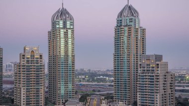 Dubai Marina skyscrapers aerial day to night transition timelapse, port with luxury yachts and marina promenade, Dubai, United Arab Emirates. Illuminated towers and traffic on the road clipart