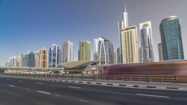 Jumeirah göl kuleleri, gökdelenler ve metro istasyonları, Şeyh zayed yolu ve tramvay hattı trafiğiyle son sürat gidiyorlar. Mavi gökyüzüyle güneşli bir gün