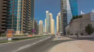 Dubai Yat Limanı gökdelenler timelapse hyperlapse ve beton yolu Köprüsü kanal aracılığıyla sokakta trafik ile. Mavi gökyüzü güneşli gün. Dubai, Birleşik Arap Emirlikleri.
