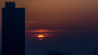 Dubai şehir merkezinde sisli bir sabah gündoğumu. Kızıl gökyüzü sisli, şehrin gelecekteki görüntüsü. Modern kuleleri olan çatıdan havadan yakın görüntü. Dubai, BAE