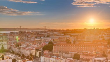 Lizbon, gün batımında, Portekiz 'in sonbahar akşamında şehir merkezinin kırmızı çatılı manzarası. Arkaplanda köprü var. Miradouro da Nossa Senhora do Monte bakış açısından üstten görünüm