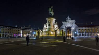 Triumphal arch at Rua Augusta and illuminated bronze statue of King Jose I at Commerce square lited at night timelapse hyperlapse in Lisbon, Portugal.