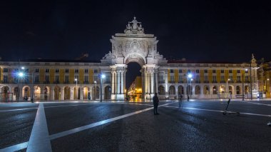 Triumphal arch at Rua Augusta at Commerce square illuminated at night timelapse hyperlapse in Lisbon, Portugal. People walking around