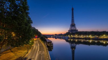 Eiffel Tower and the Seine river night to day transition timelapse before sunrise, Paris, France. Morning panoramic view from Bir-Hakeim bridge with reflections on water clipart