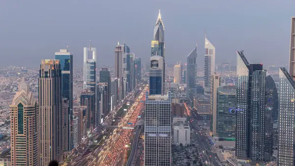 Dubai şehir manzarası gün gece geçiş timelapse için. Çok sayıda ışıklı Kuleli Şeyh Zayed Yolu üzerinde trafik çatı görünümü.