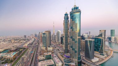 Dubai, Bae gece geçiş timelapse için şeyh zayed yol gün modern gökdelenler ve trafik ile Akşam silueti. İş koyu mimarisinin havadan görünümü.