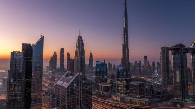 Dubai şehir merkezi silueti en yüksek gökdelenler ve karayolu kavşak gece gündüz geçiş timelapse üzerinde en işlek trafik ile. Yukarıdan havadan görünüm