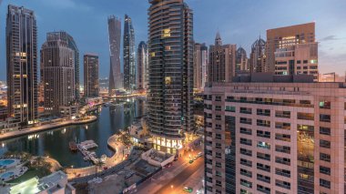 Dubai Marina yerleşim yerlerinin ve ofis gökdelenlerinin hava panoramik görüntüsü. Gün doğmadan önce gece gündüz geçiş zamanı. Yüzen tekneler ve yatlar