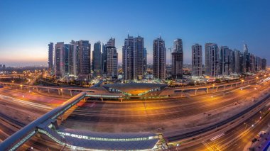 Dubai Marina 'dan Sheikh Zayed yoluna gece gündüz aydınlık gökdelenler ile hava panoramik görüntüsü, geçiş zamanı, Dubai. Trafik, köprüler ve metro istasyonu. Birleşik Arap Emirlikleri