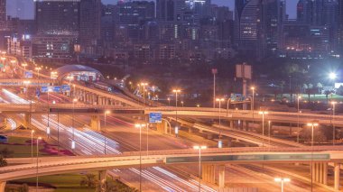 Dubai Golf Sahası 'nın arka planda yeşillik ve tekom bölgelerinden oluşan bir manzarası var. Gece gündüz geçiş zamanı. Şeyh zayed yolunda trafik kesişiyor.