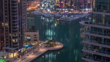 Dubai Marina 'daki rıhtım güvertesi gece gündüz geçiş zamanı. Kanalda yüzen tekne ve yatlar. Dubai, Birleşik Arap Emirlikleri