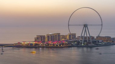 Dubai Bluewaters Adası gün batımından sonra gece geçiş zaman aşımına uğrar Dubai havadan. Jumeirah Beach Residence kıyılarında bulunan insan yapımı karma kullanımlı ada