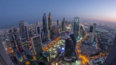 Sheikh Zayed Yolu yakınlarındaki binaların silueti ve Dubai, BAE 'deki hava trafiği gece gündüz değişiyor. Gündoğumundan önce finans merkezinde ve şehir merkezinde modern kuleler ve aydınlık gökdelenler