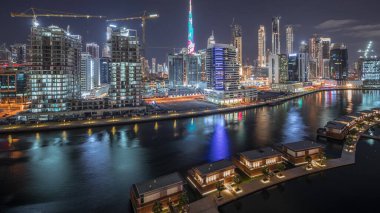 Parlak yolları ve caddeleri olan, geceleri Business Bay ve Downtown 'ın yüksek gökdelenleri bulunan, Dubai, Birleşik Arap Emirlikleri, Kanal Hava Zaman Çizelgesi yakınlarındaki büyük şehir manzarası.