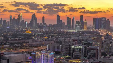 Şehir merkezinde büyük gökdelenler ve onlardan gelen ışıklar ve renkli gökyüzü, Dubai, Birleşik Arap Emirlikleri ile finans bölgesi Timelapse 'nin havadan görünüşü