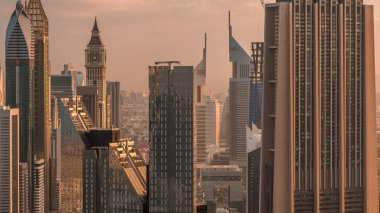 Dubai Uluslararası Finans Merkezi semt ışıklı modern gökdelenler sabah timelapse ile. Sıcak ışık ile gün doğumu sırasında sokaklarda trafik ile Downtown havadan görünümü