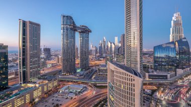 Yoğun yolları olan yeni ve yüksek binaların hava manzarası. Dubai 'de günden geceye geçiş. Şehir merkezinden Dubai' ye, Birleşik Arap Emirlikleri.