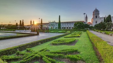 Günbatımında Mosteiro dos Jeronimos (Hieronymites Manastırı), Lizbon 'un Belem ilçesinde, bahçede yeşil çimenlik alan. Manueline stilinin tipik bir örneği. Dünya Mirası Sitesi