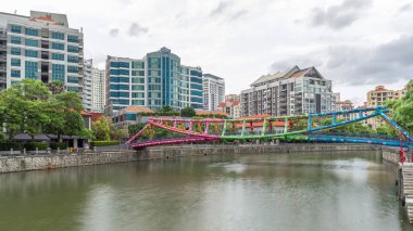 Alkaff Bridge on the Singapore River at Robertson Quay with dark gray clouds timelapse hyperlapse. Buildings reflected on a water clipart