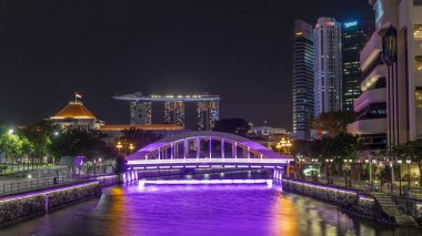 Singapur finans bölgesinin Skyline 'ı ve Elgin Köprüsü' nün arkasındaki Marina körfezi ve Singapur Nehri gece hipervanesi. Parlamento binası sol tarafta.