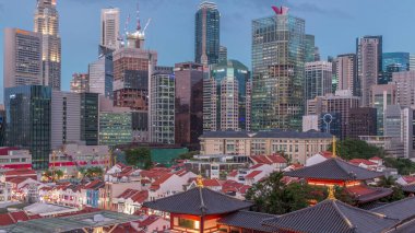 Buddha Diş Kalıntısı Tapınağı Singapur Çin Mahallesi 'nde gece gündüz canlanıyor. Arka planda şehrin silüeti var. Tapınak gökdelenler ve kulelerle aydınlık