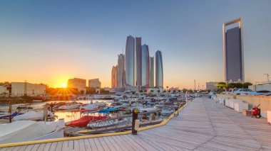 Al Bateen marina Abu Dhabi at sunset timelapse with boats and modern skyscrapers on background clipart