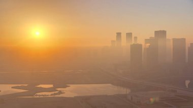 Abu Dabi şehrinin gökdelenleri gökdelenlerle kaplı. Çatıdan sisli bir sabahta hava manzarası