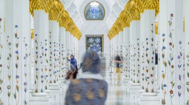 Birleşik Arap Emirlikleri 'nin başkenti Abu Dabi' deki Şeyh Zayed Büyük Camii zaman çizelgesi. Sütunlar arasında yürüyen insanlar.