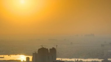 Sunrise with the city scape of Ajman from roof airial time apse. İnşaat alanı ve turuncu gökyüzü. Ajman, Birleşik Arap Emirlikleri 'nde Ajman Emirliğinin başkentidir..