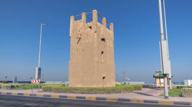 Ajman zaman kulesinin mavi gökyüzü ve yoldaki trafik hızını izleyin. Birleşik Arap Emirlikleri