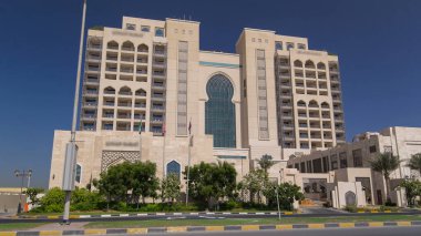 Ajman 'da 5 yıldızlı lüks bir otelin girişinde, UAE' nin Arap Körfezi turkuaz sularının yakınındaki bir yolda trafik vardı..