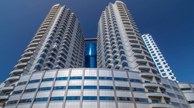 Ajman zaman ayarlı hiperhızlandırılmış gümüş kuleleri olan modern yeni mavi. Ajman 'ın yerleşim yeri ve ofis gökdelenleri olan şehir manzarası. Birleşik Arap Emirlikleri.