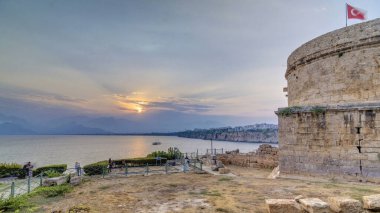 Türkiye 'nin Kas ilçesinde gün batımında Hidirlik kulesi, liman sahili manzaralı eski bir şehirdir. Yaz akşamında turuncu bulutlu gökyüzü