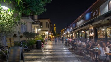 Kaleiçi timelapse hyperlapse Kesik Minare Camii cami Antalya'da kırık Minare üzerinde gece manzaralı tarihi cadde boyunca yürüyüş. Etrafta dolaşan insanlar