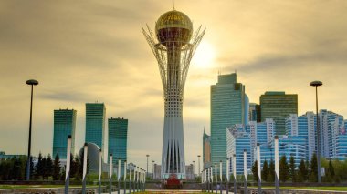 Astana 'nın başkenti Kazakistan' daki Bayterek Kulesi 'nde gün batımı için güzel bir zaman dilimi. Arka planda modern binalar ve gökdelenler var. Turuncu gökyüzü. Nur-Sultan şehri, Kazakistan