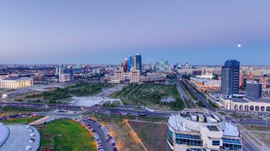 Şehir merkezi ve merkez iş bölgesi üzerindeki manzaranın günden geceye yükselmesi geçiş zamanı çatısı, Orta Asya, Kazakistan, Astana