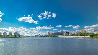Astana, Kazakistan. Keyif teknesinden Astana 'da Ishim nehrinde hareketli bir seyahat görüntüsü. Mavi gökyüzü ve bulutlarla dolu bir yaz gününde. Bulanık hareket