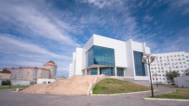 Kurumsal Skylines: Kazakistan 'ın Atyrau şehrindeki Modern Ofis Binalarının Zaman Hızlandırması. Güneşli Bir Gün, Mavi Bulutlu Gökyüzüne Karşı Sahneyi Ayarladı, Şehir Tutkusunu Gösteriyor