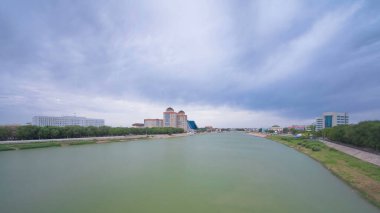 Atyrau City 'deki Ural Riverside' daki Modern Evlerin Zaman Hızı. Bir köprüden hava görüntüsü, Kazakistan 'da akan sularla birlikte dinamik şehir manzarasını yakalıyor.