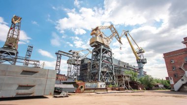 The construction of a large ship on a shipyard with cranes timelapse hyperlapse. A fragment of the case in the workshop of the plant. Metal frame during assembly