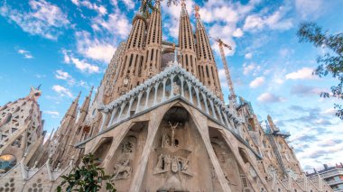 Sagrada Familia Timelapse Hyperlapse, Barcelona, İspanya 'da. Büyüleyici Sonbahar Sahnesi, Yeşil Ağaçlarla süslenmiş Mavi Bulutlu Gökyüzüne karşı