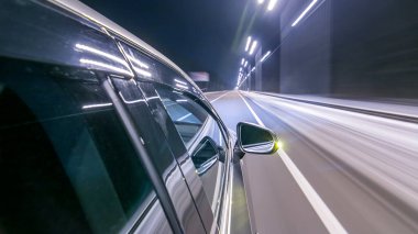 Sokaklarda yüksek hızda araba sürerken zaman ayarlı süratli sürat. Gece şehir yolunda sürgülü hareket ile arabanın yanından görüntüle