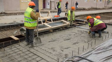 Beton, yol bakım şantiyesinde çok sayıda işçi ve mikser zaman ayarlı çalışıyor. Tramvay raylarının yeniden inşası