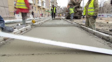 Beton karıştırıcı hızlandırıcı hiperhızlandırıcıyla yolu açmak için çelik takviyesi yaptıktan sonra hazır beton döküp düzleştiriyorlar. Tramvay raylarının yeniden inşası