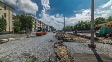 Turuncu titreşimli sıkıştırıcılar yol yapımında ve tamir zamanlarında ezilmiş taşların üzerinde yuvarlanıyor. Tramvay raylarının yeniden inşası